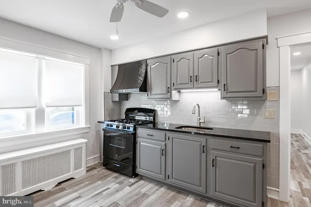 a kitchen with kitchen island granite countertop a sink stainless steel appliances and cabinets