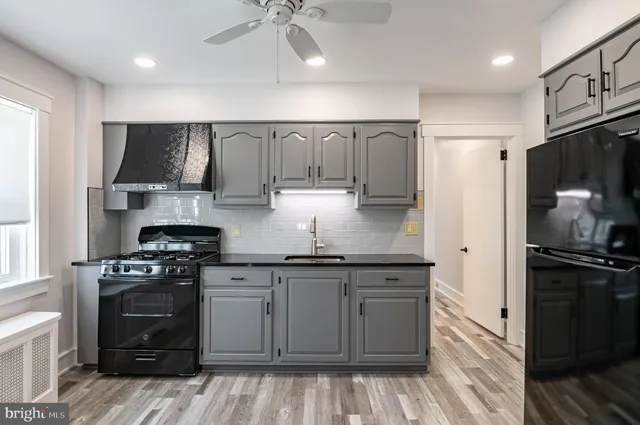 a kitchen with granite countertop a stove a sink and a refrigerator