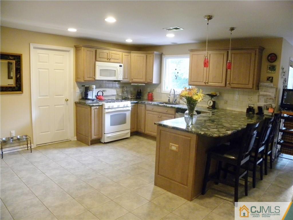 13 Russett Road Somerset, NJ 08873 - Photo 6 of 20 a kitchen with kitchen island a sink stove and cabinets