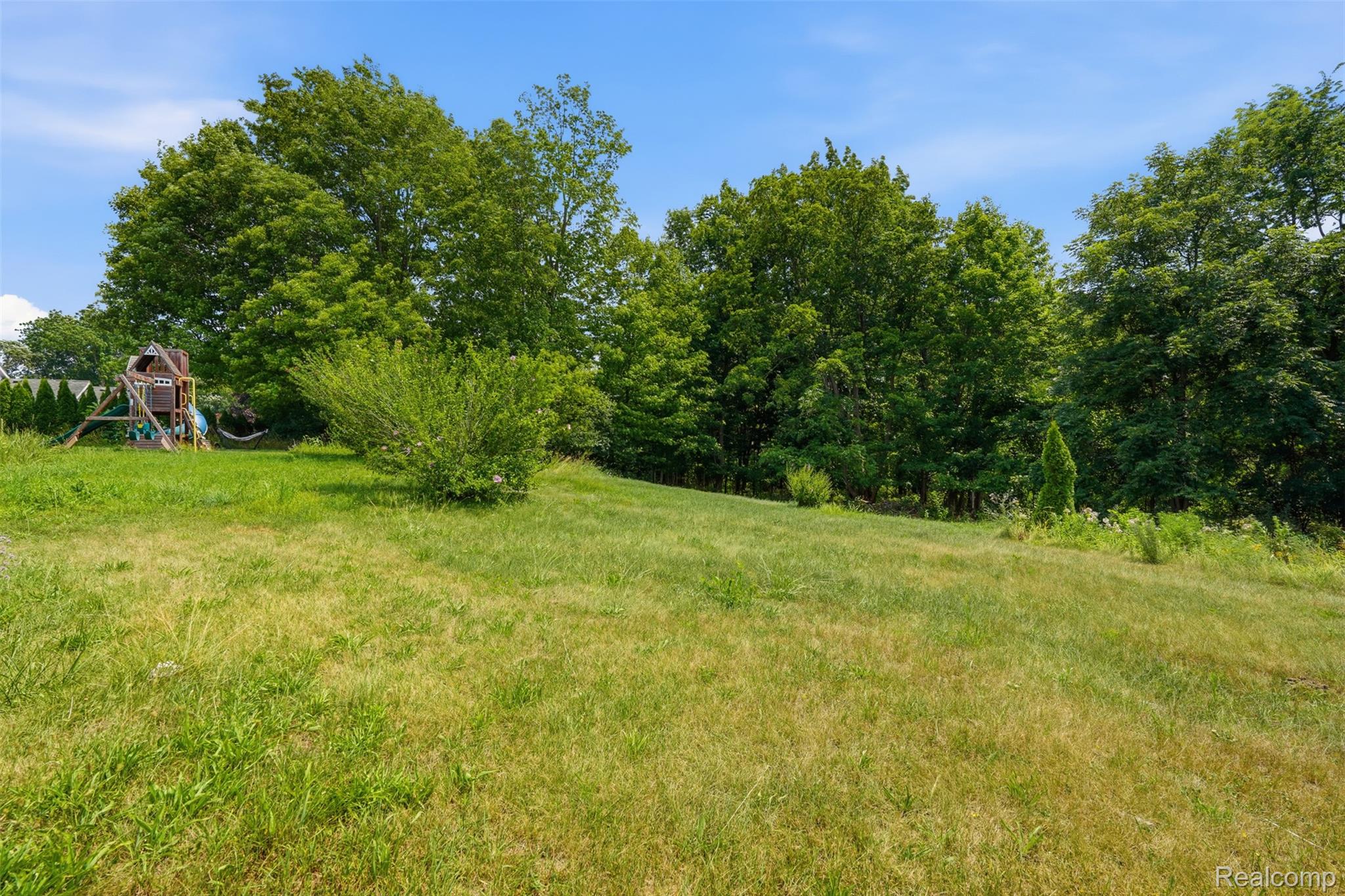 31000 Drake Road Farmington, MI 48331 - Photo 36 of 44 Expansive green space featuring a gentle slope and mature trees bordering the property
