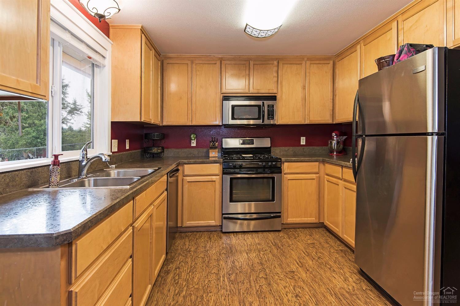 63635 Boyd Acres Road Bend, OR 97701 - Photo 6 of 25 a kitchen with stainless steel appliances a refrigerator sink and microwave