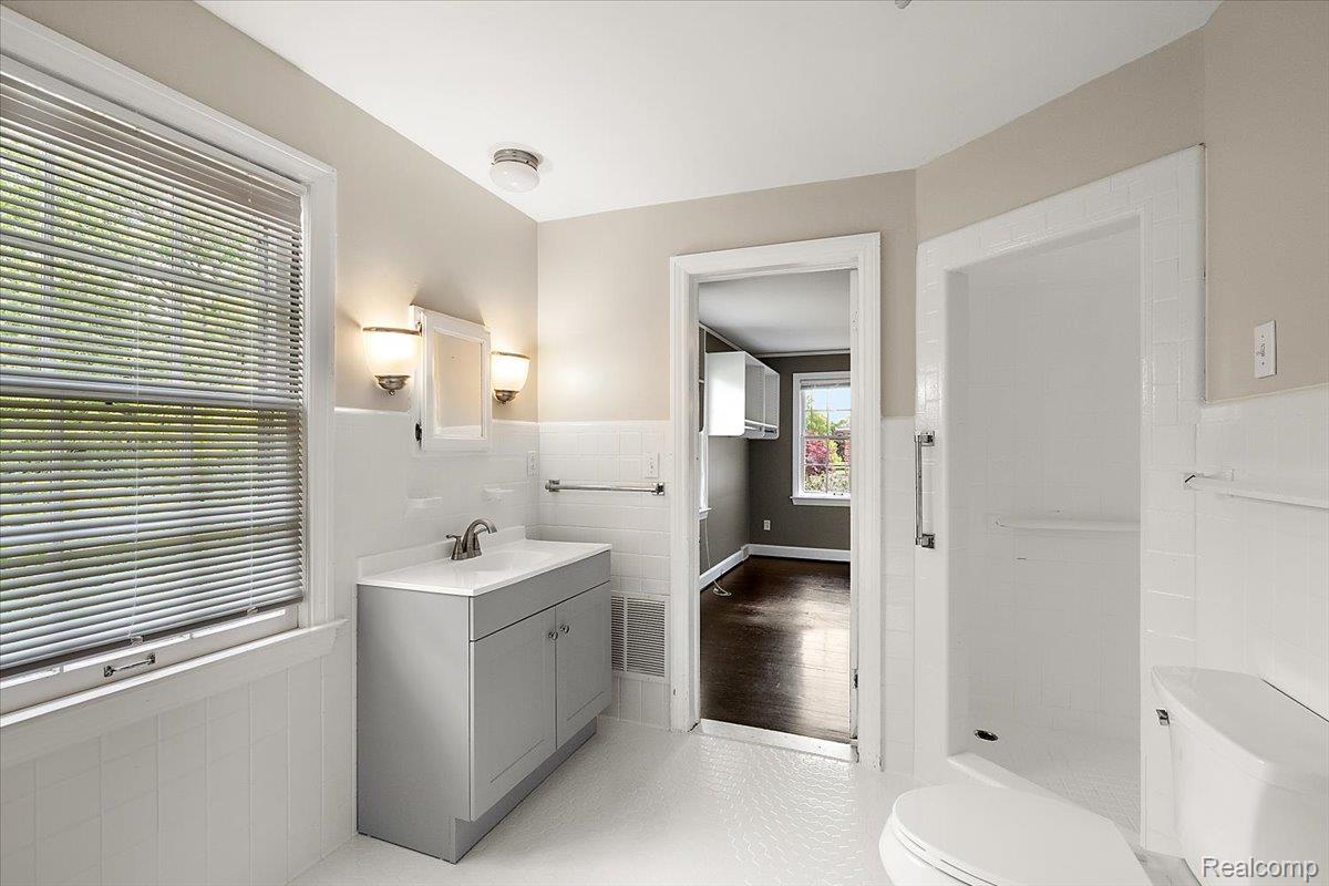 1051 Devonshire Road Grosse Pointe, MI 48230 - Photo 35 of 99 Bathroom featuring a single vanity with a gray cabinet, a white countertop, and a brushed nickel faucet