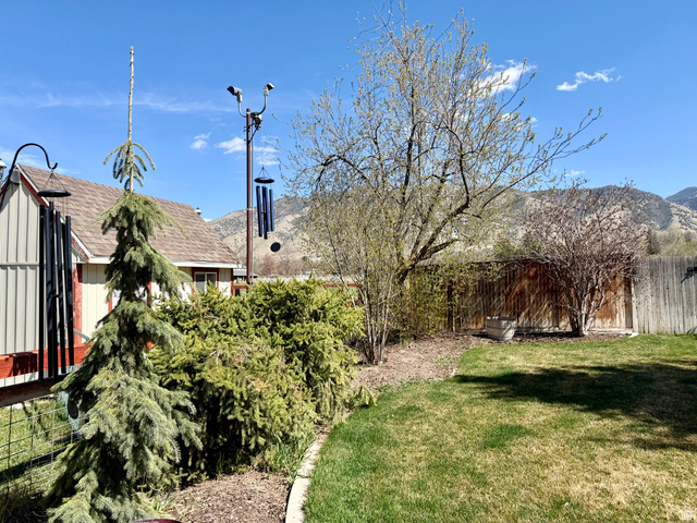 202 375 West Providence, UT 84332 - Photo 35 of 61 View of landscaping of fenced backyard with outside lighting