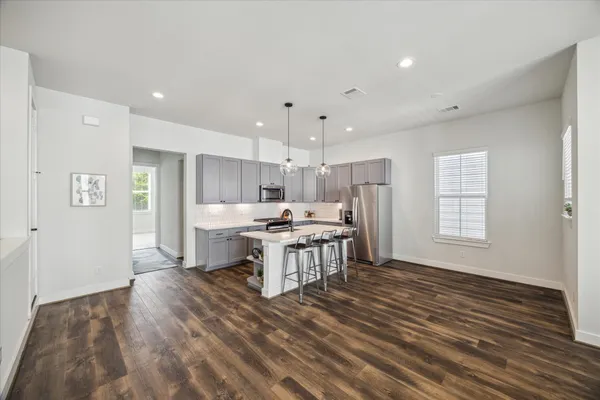 a kitchen with stainless steel appliances kitchen island hardwood floor sink stove and cabinets