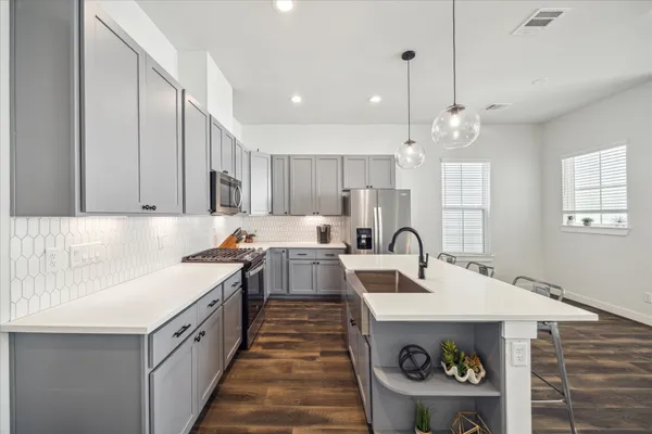 a large kitchen with kitchen island a sink stainless steel appliances and cabinets