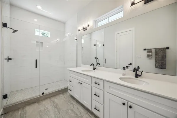 a bathroom with double sink and a mirror