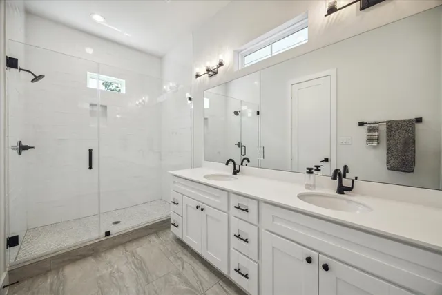 a bathroom with double sink and a mirror