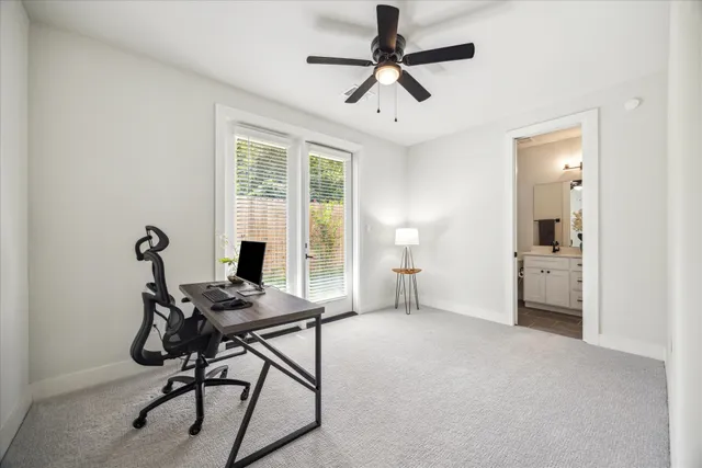 a view of a workspace with furniture and a window