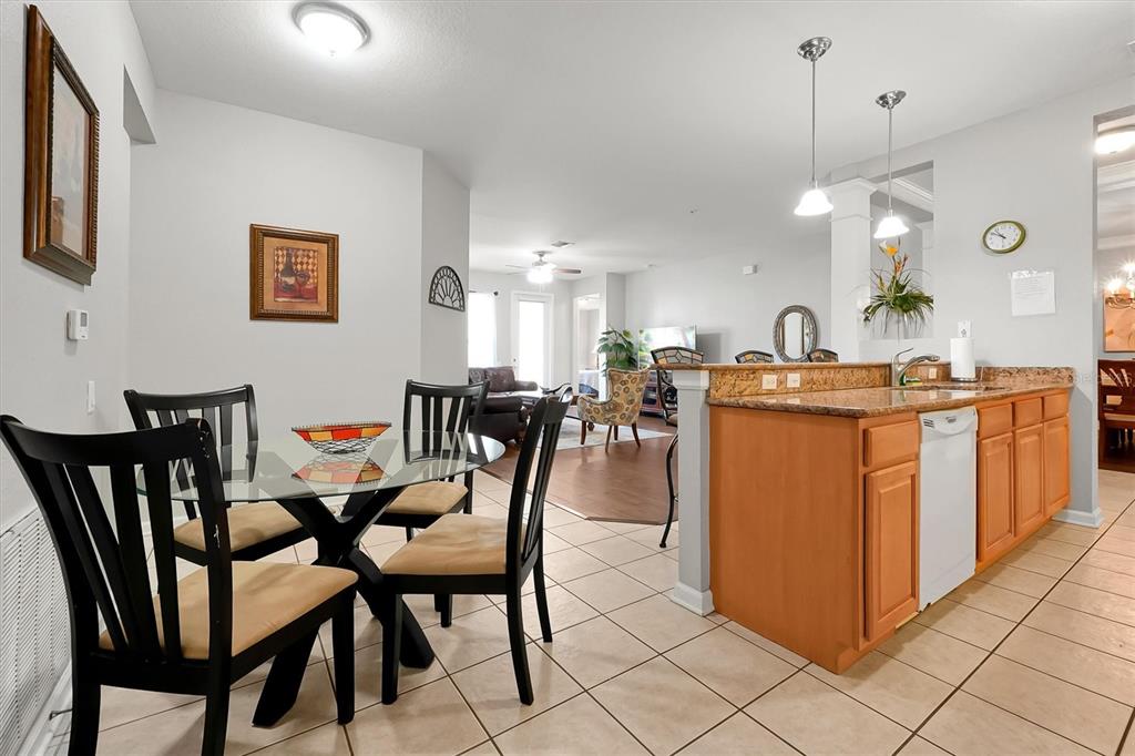 5036 Shoreway Loop, Unit 30105 Orlando, FL 32819 - Photo 12 of 49 a dining room filled a chandelier and kitchen view