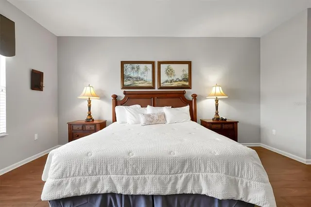 a bedroom with a bed and a flat tv screen on a dresser