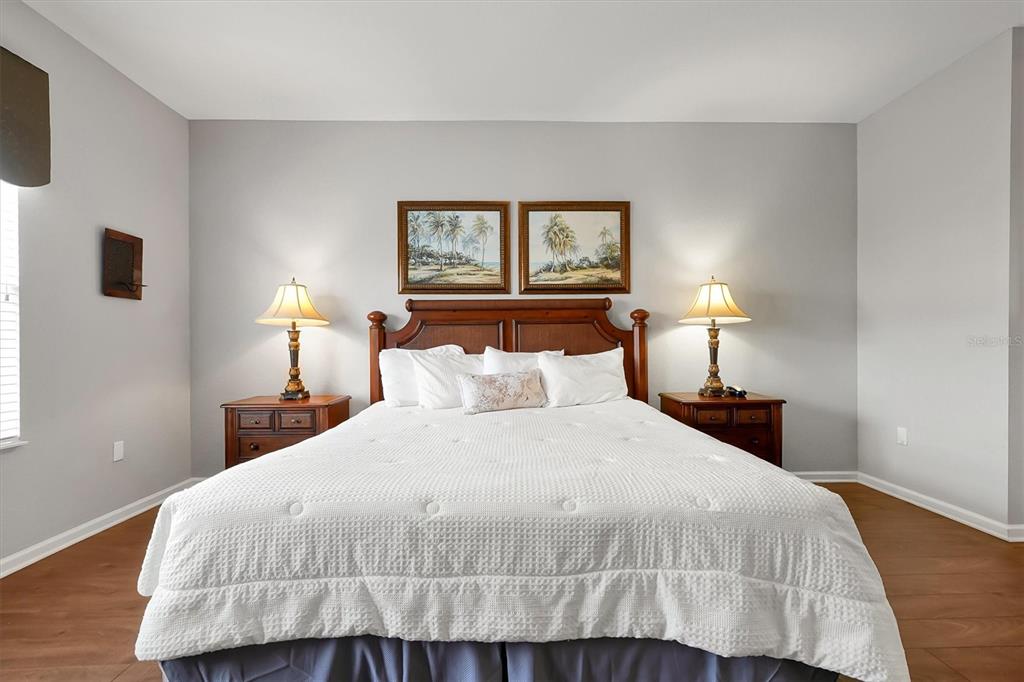 5036 Shoreway Loop, Unit 30105 Orlando, FL 32819 - Photo 15 of 49 a bedroom with a bed and night stand