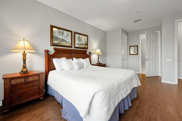 a bedroom with a bed and a painting on the wall