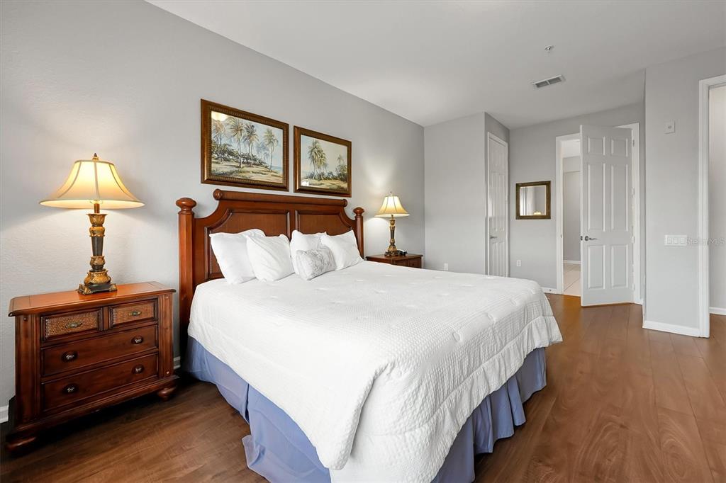 5036 Shoreway Loop, Unit 30105 Orlando, FL 32819 - Photo 16 of 49 a bedroom with a bed and a lamp on dresser and a window