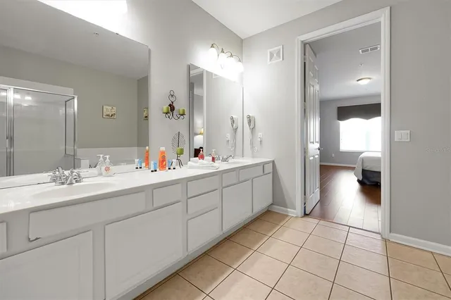 a bedroom with a bed and a lamp on dresser