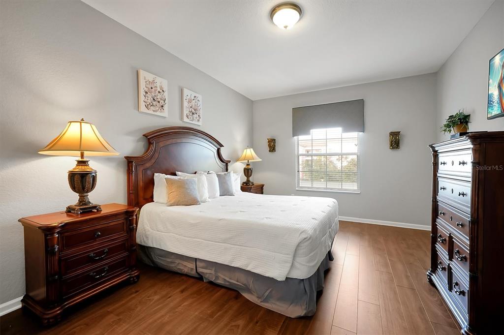 5036 Shoreway Loop, Unit 30105 Orlando, FL 32819 - Photo 21 of 49 a bedroom with a bed and a flat tv screen on a dresser