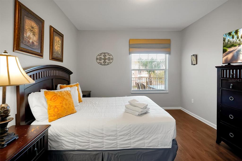 5036 Shoreway Loop, Unit 30105 Orlando, FL 32819 - Photo 24 of 49 a bedroom with a bed and wooden floor
