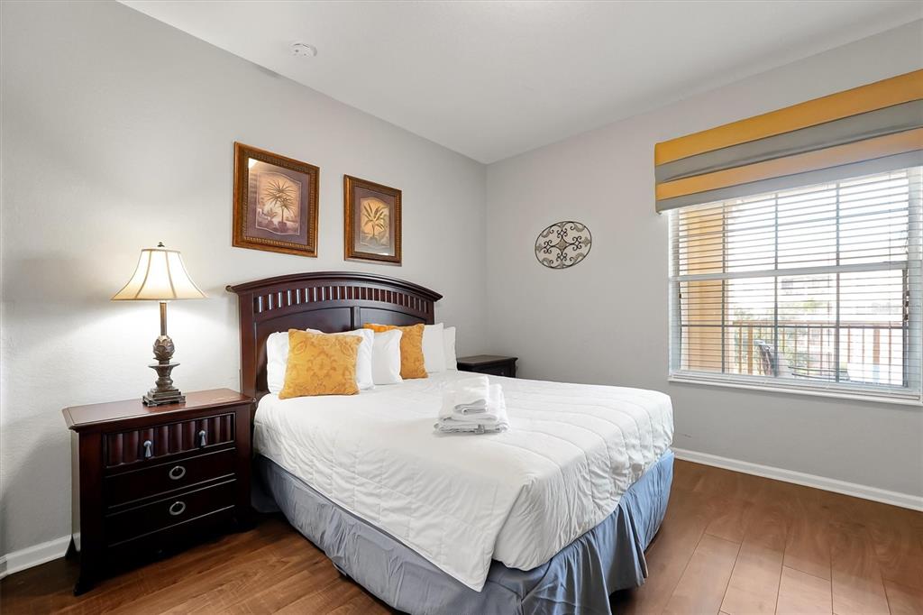 5036 Shoreway Loop, Unit 30105 Orlando, FL 32819 - Photo 25 of 49 a bedroom with a bed and a lamp on dresser