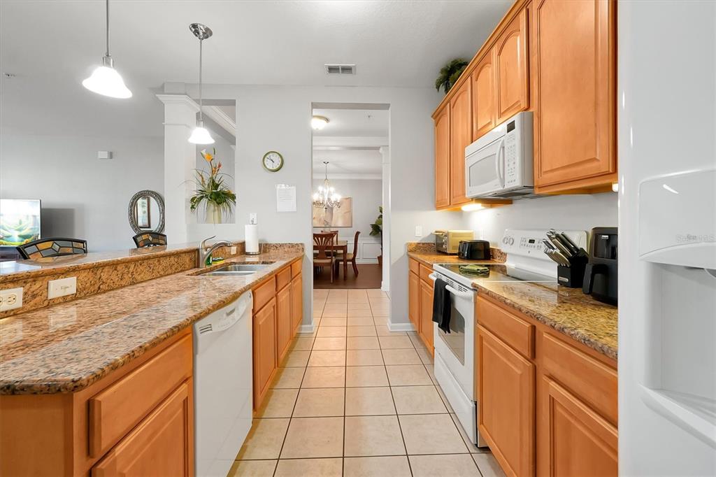 5036 Shoreway Loop, Unit 30105 Orlando, FL 32819 - Photo 9 of 49 a large kitchen with stainless steel appliances granite countertop a stove a sink and a refrigerator