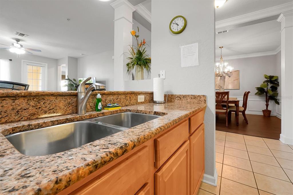5036 Shoreway Loop, Unit 30105 Orlando, FL 32819 - Photo 10 of 49 a kitchen with a sink and a view of living room
