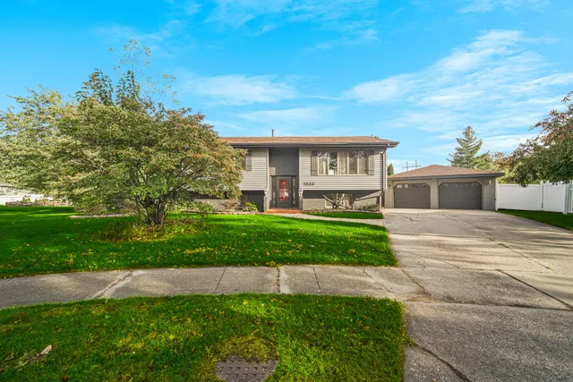 a front view of a house with a yard and potted plants