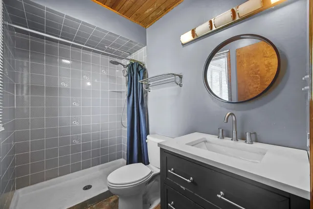 a bathroom with a sink a toilet and a mirror