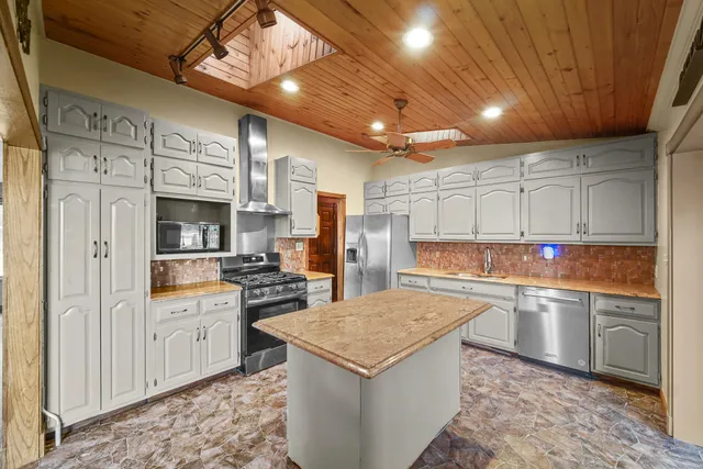 a kitchen with stainless steel appliances granite countertop a sink stove and refrigerator