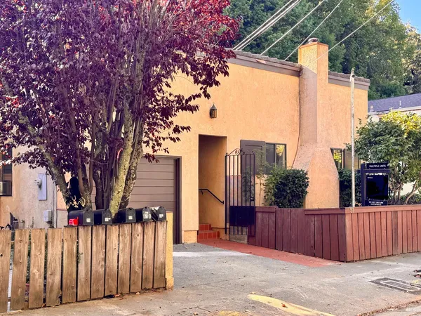 a view of a house with wooden fence next to a road