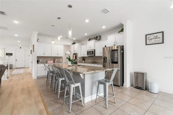 a kitchen with stainless steel appliances granite countertop a refrigerator and a sink
