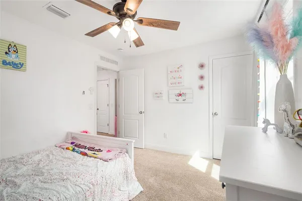 a bedroom with a bed and a flat tv screen on dresser