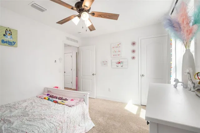 a bedroom with a bed and a flat tv screen on dresser