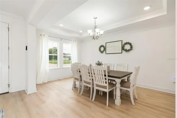 a view of a dining room with furniture wooden floor and chandelier