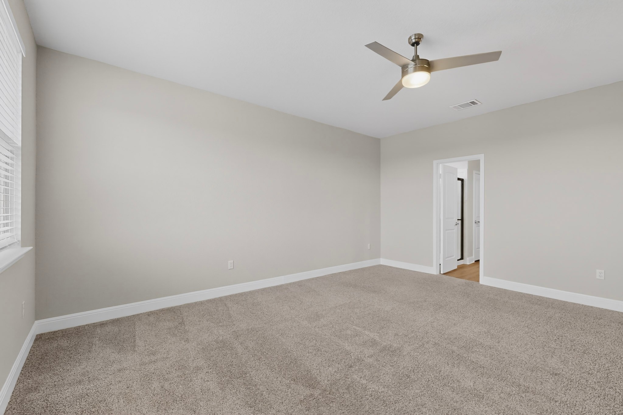 16809 Guido Cove Pflugerville, TX 78660 - Photo 17 of 40 Spacious room with plush carpet flooring, neutral paint, a modern ceiling fan, and window blinds