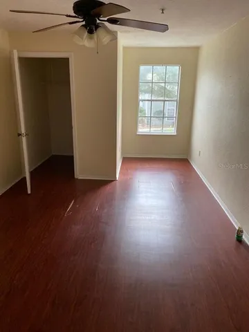an empty room with a window and a ceiling fan