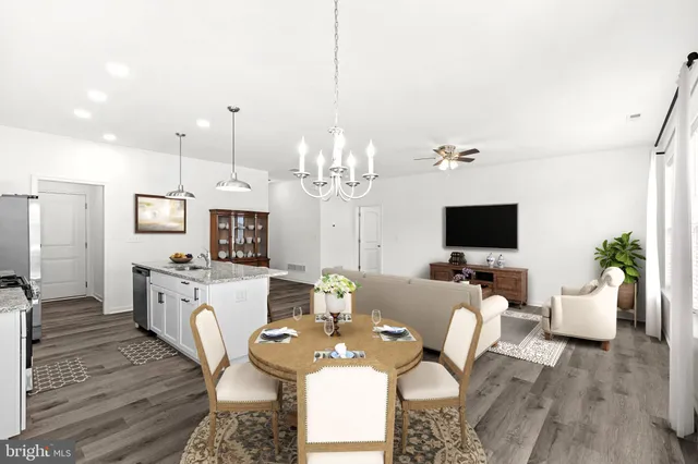 a large kitchen with stainless steel appliances kitchen island a large counter top and wooden floors