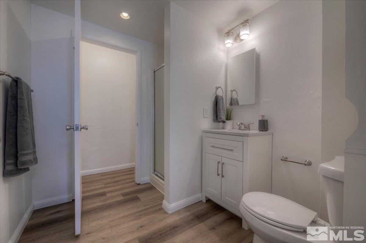 485 East 7th Street Reno, NV 89512 - Photo 22 of 31 a bathroom with a toilet a sink and wooden floor