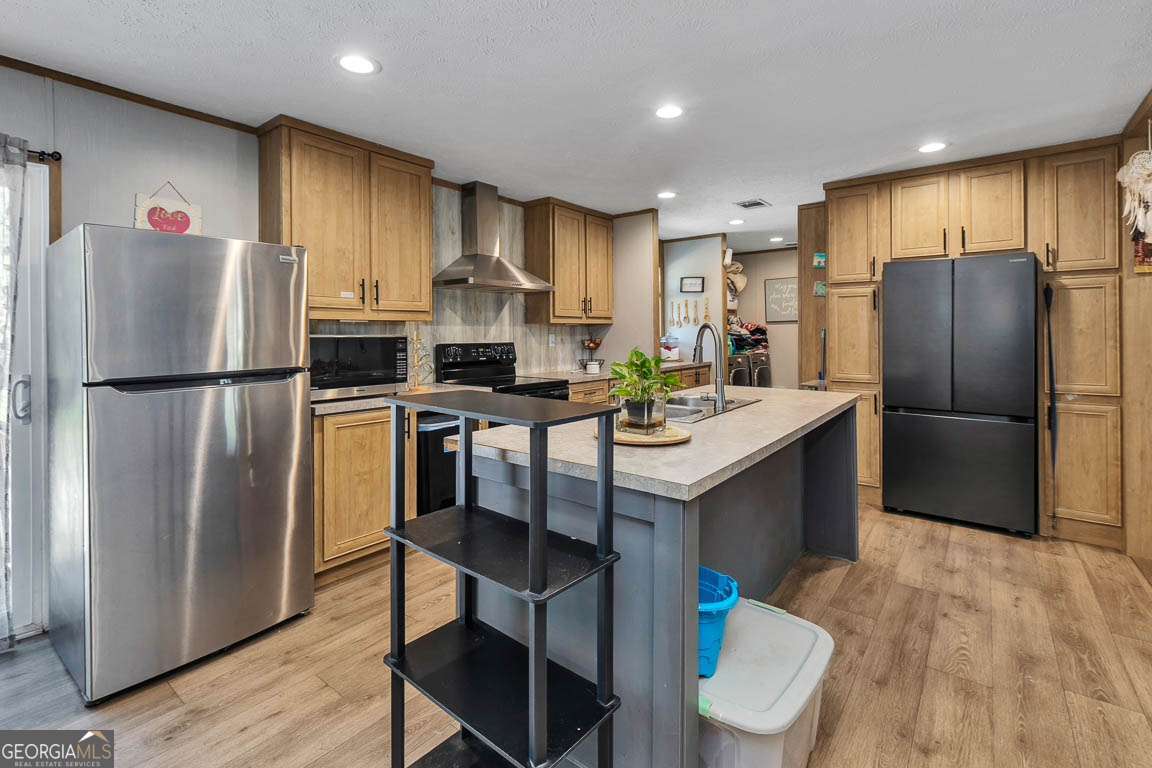 3069 Mineral Springs Road Waynesville, GA 31566 - Photo 11 of 35 a kitchen with stainless steel appliances a refrigerator stove microwave and cabinets