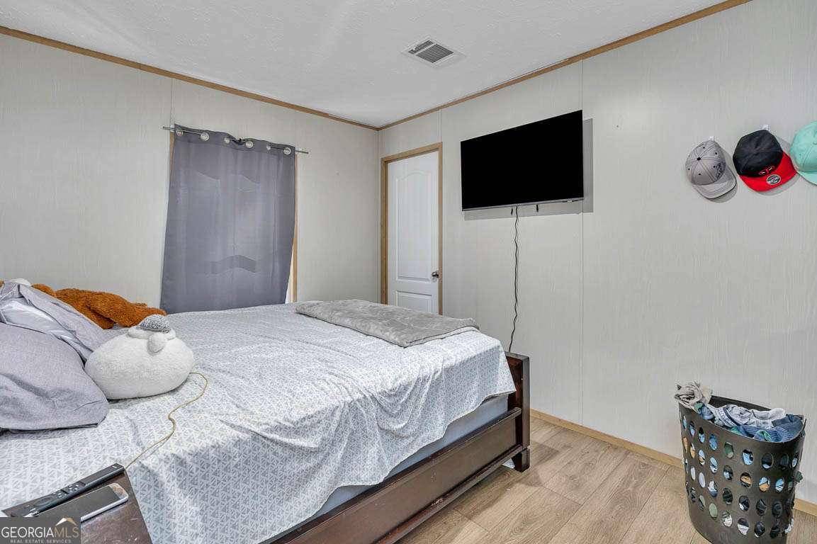 3069 Mineral Springs Road Waynesville, GA 31566 - Photo 21 of 35 a bedroom with a bed and a flat screen tv