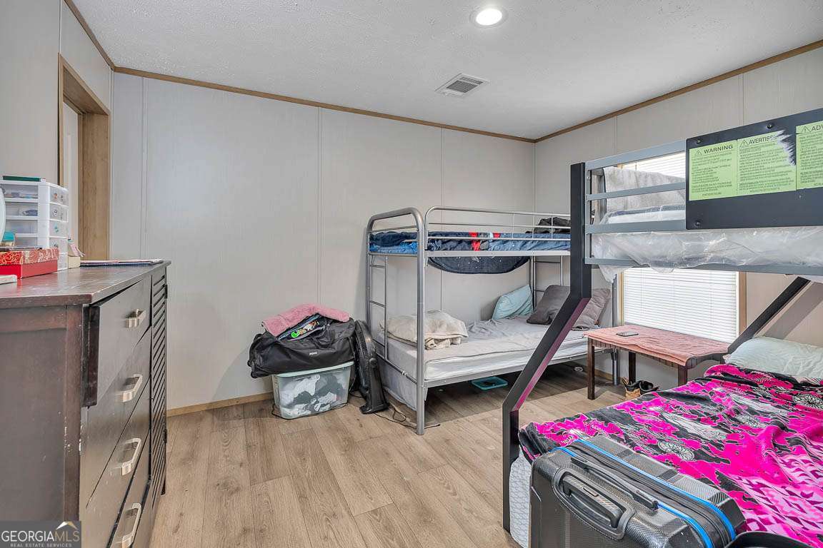 3069 Mineral Springs Road Waynesville, GA 31566 - Photo 26 of 35 a bedroom with a bed and wooden floor