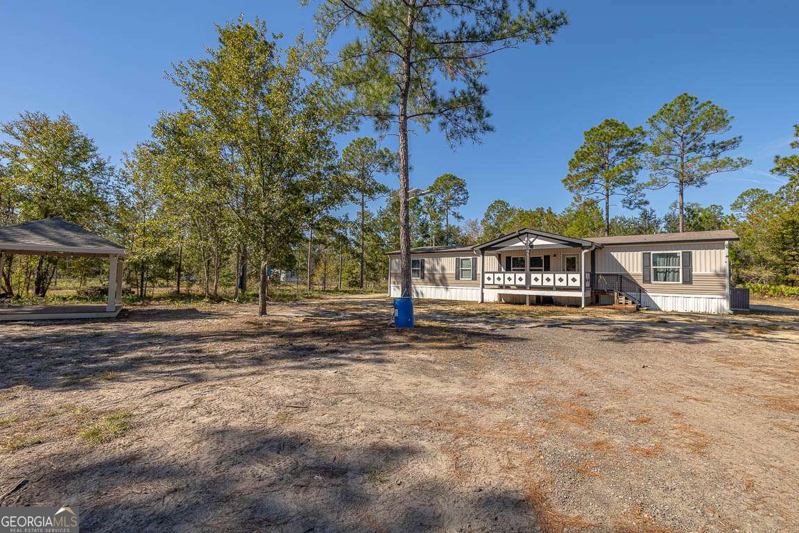 3069 Mineral Springs Road Waynesville, GA 31566 - Photo 3 of 35 a view of a house with a yard and tree s