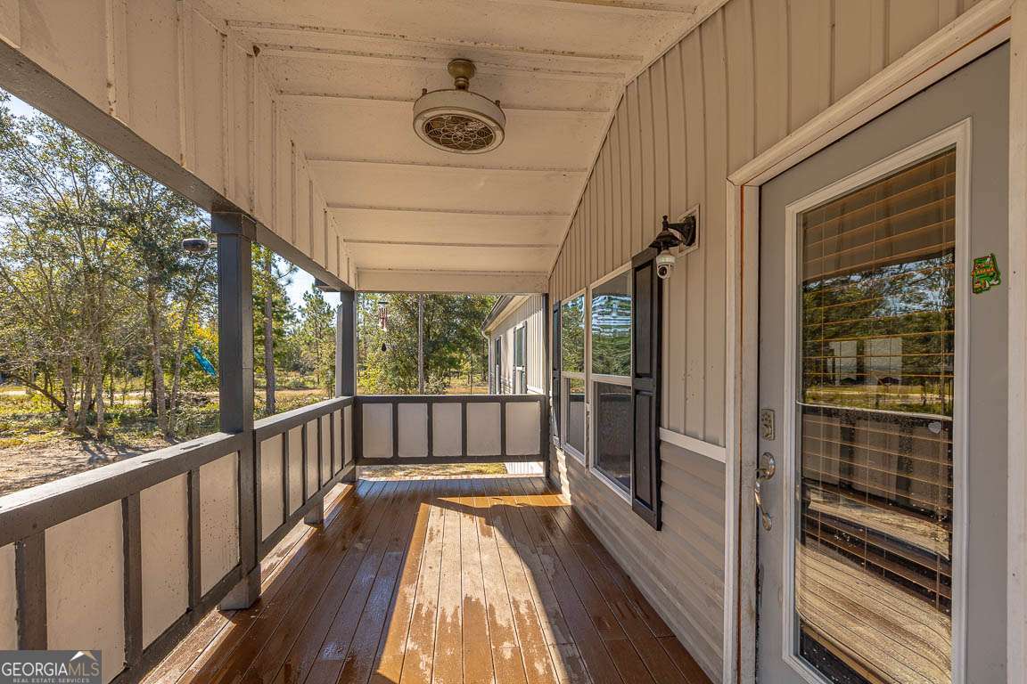 3069 Mineral Springs Road Waynesville, GA 31566 - Photo 5 of 35 a view of balcony with a floor to ceiling window with wooden floor
