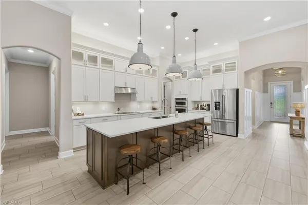 a large kitchen with a counter space a sink stainless steel appliances and cabinets
