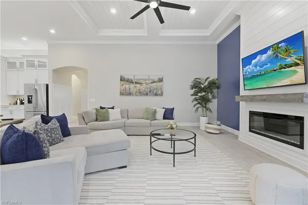 a living room with furniture a fireplace and a flat screen tv