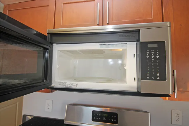 a view of an empty room with chandelier fan and a window