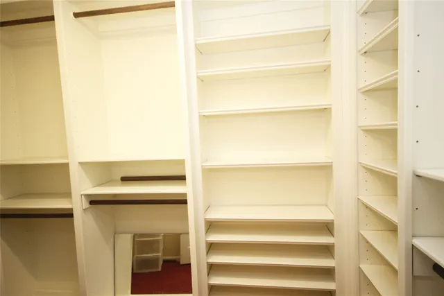 a view of a big room with wooden floor and a window