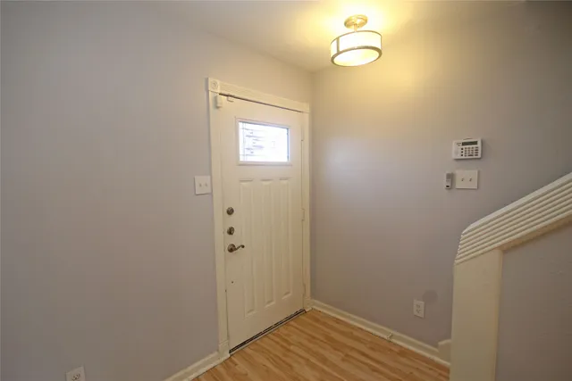 a view of empty room with a fireplace and wooden floor