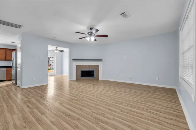 a view of empty room with wooden floor and fireplace