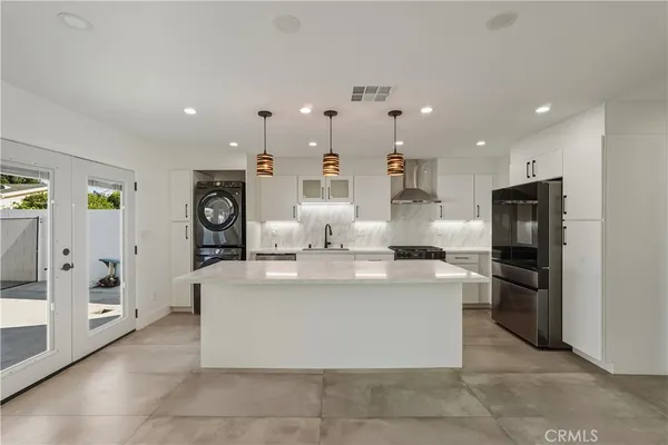 a large kitchen with stainless steel appliances kitchen island granite countertop a refrigerator a stove a sink and a stove