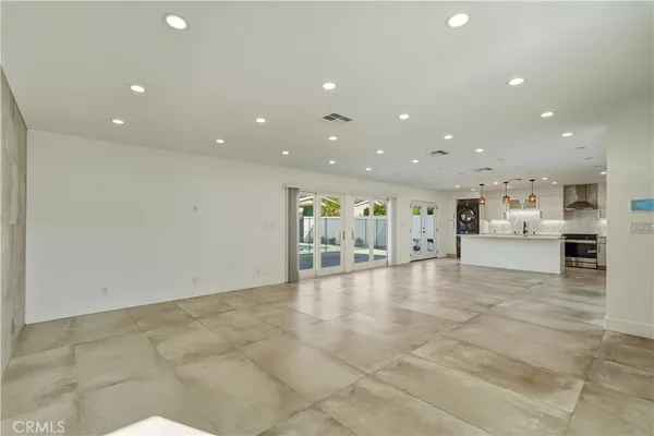 a large kitchen with stainless steel appliances kitchen island granite countertop a large counter top and a view of living room