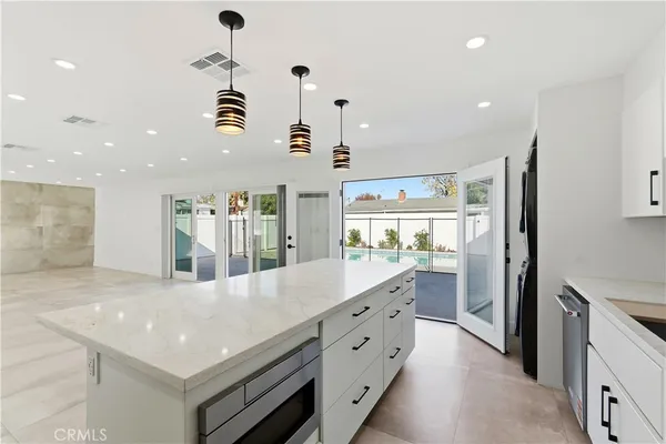 a kitchen with granite countertop a stove and a wooden floors