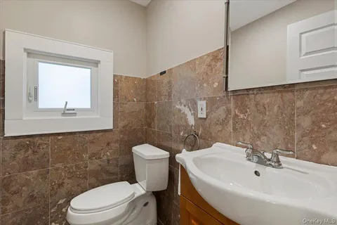 a bathroom with a sink a toilet and a mirror